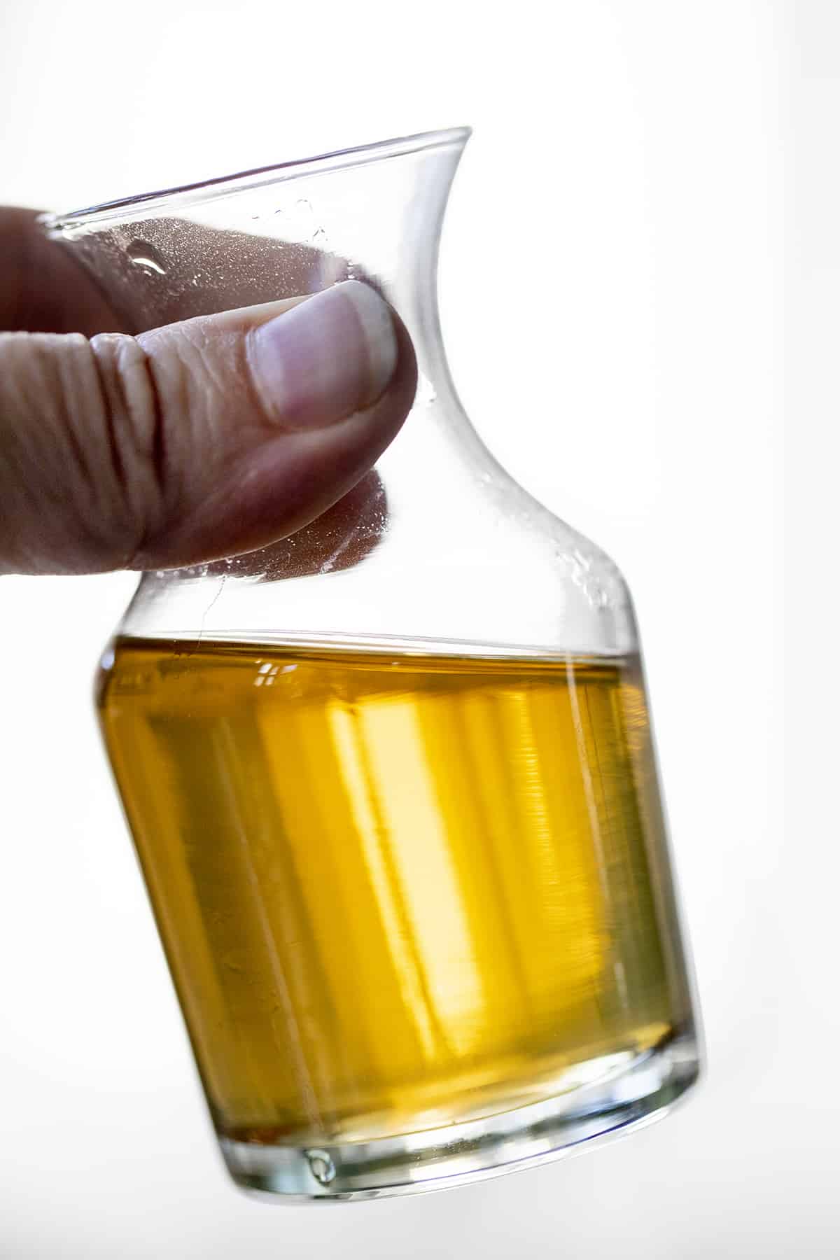 手拿着一瓶香草简单的糖浆。简单的糖浆,如何制作简单的糖浆,香草简单的糖浆,如何使用简单的糖浆,鸡尾酒糖浆、饮料,饮料,食谱,iambaker,我是贝克。